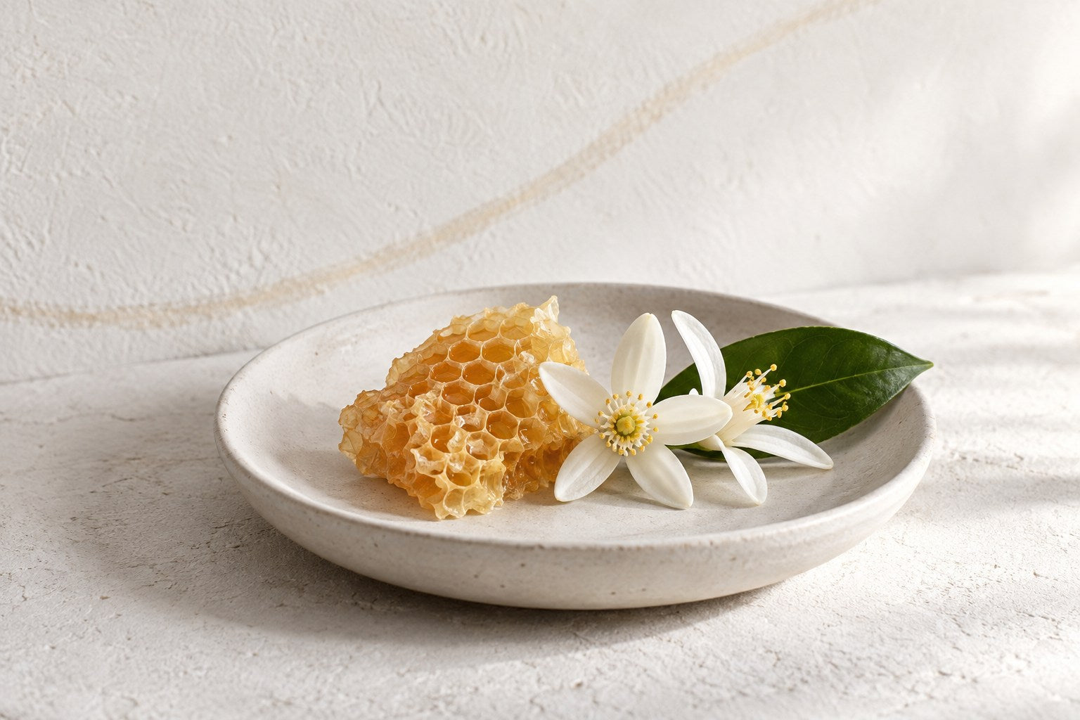 Rayon de miel et fleurs d’oranger dans une coupelle claire